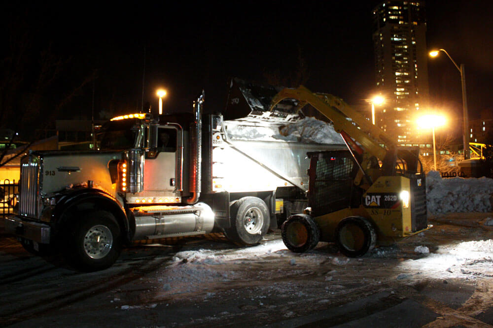 Skidsteer Loading Snow into Dump Truck